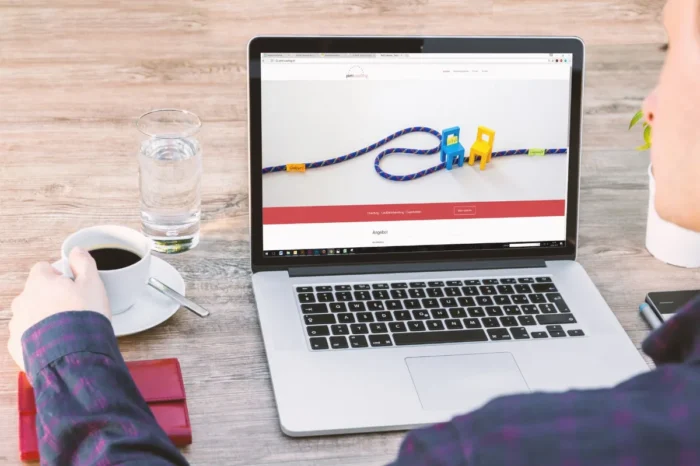 Laptop di meja kerja dengan tampilan website sederhana dan suasana ruang kerja profesional