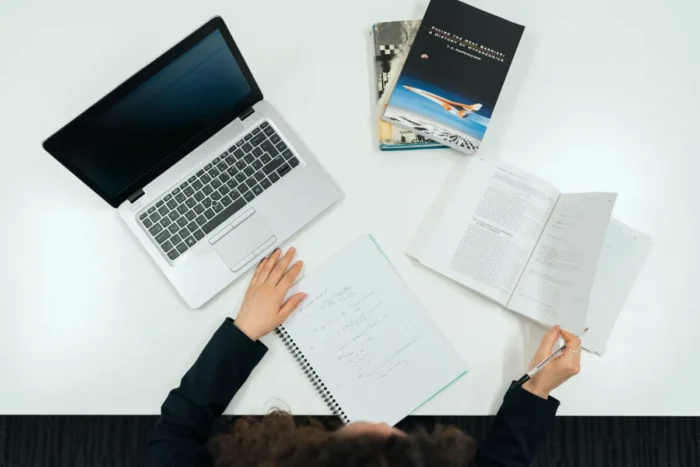 Seseorang berlatih skill di meja kerja dengan laptop dan buku catatan