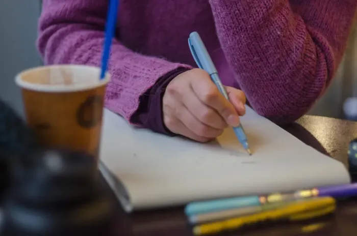 Meja kerja sederhana dengan laptop dan buku catatan untuk memulai tulisan.