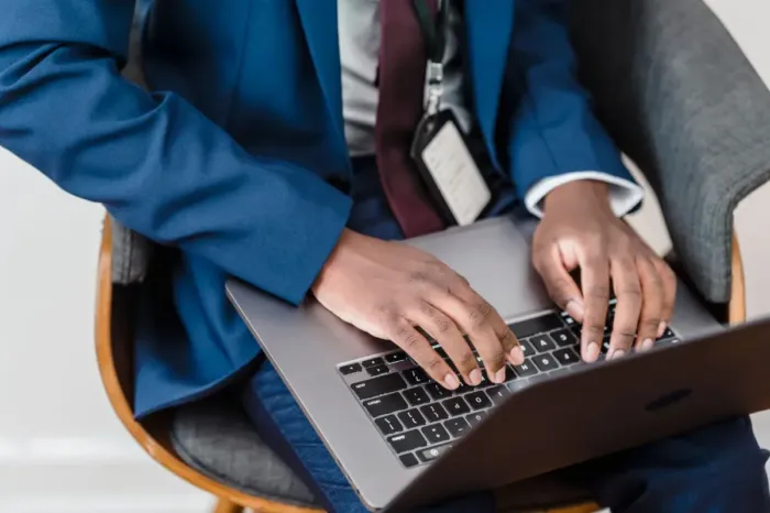 Profesional muda menyusun email kerja di laptop