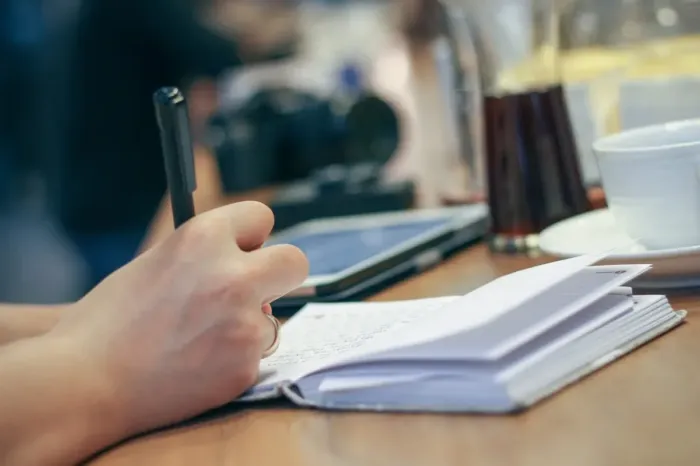 Meja kerja dengan jurnal dan laptop untuk kebiasaan menulis rutin