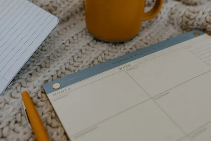 Blogger menyusun jadwal menulis mingguan di meja kerja