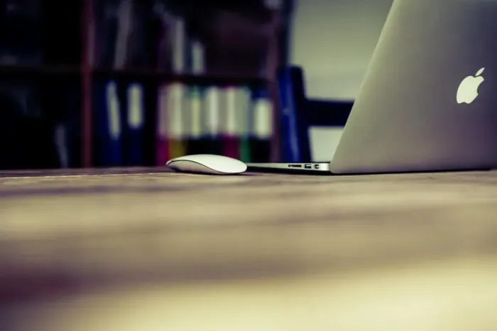 Meja kerja dengan notebook, laptop, dan grafik naik sebagai simbol hasil kerja yang berdampak