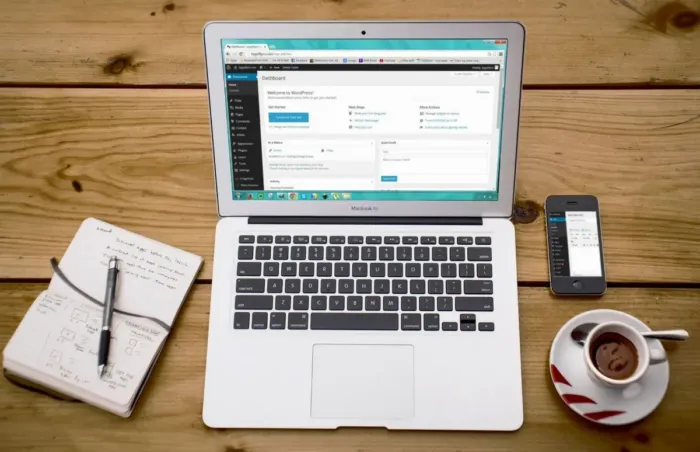 Ponsel dan laptop di meja kerja untuk menangkap ide artikel dan mengelola blog.