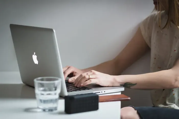 Seseorang mengerjakan desain undangan sederhana di laptop