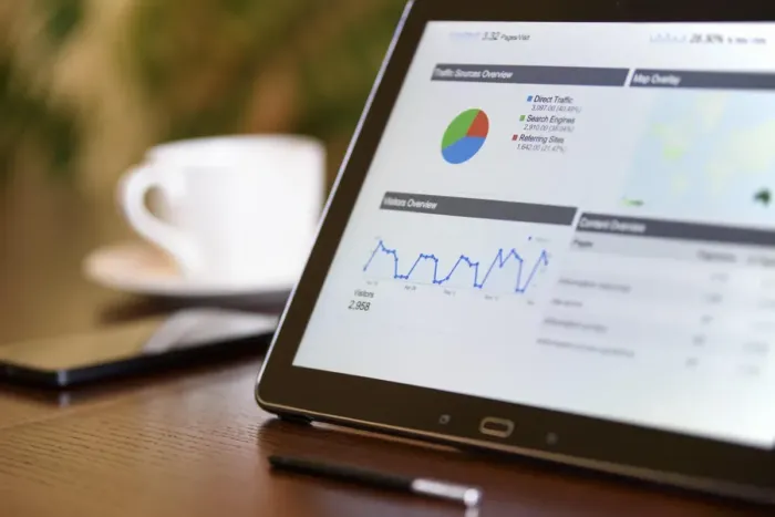 Pemilik bisnis mengevaluasi hasil kampanye lewat grafik di laptop