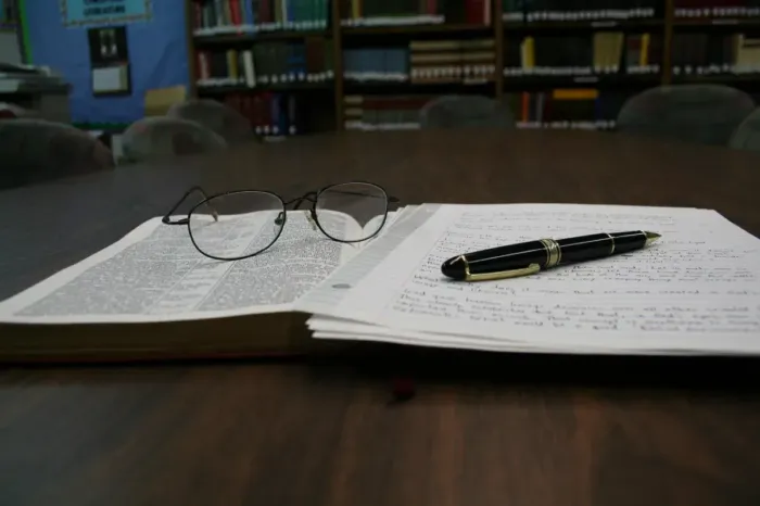 Catatan riset dan buku yang diperiksa di meja kerja