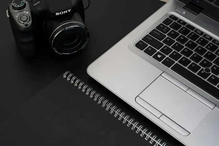 Laptop dan buku catatan di meja kerja seorang blogger profesional