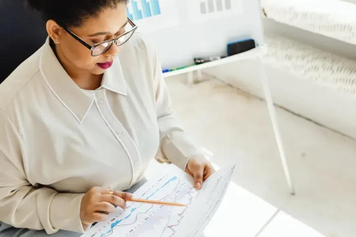 Analis memeriksa grafik dan data sebelum menyusun laporan